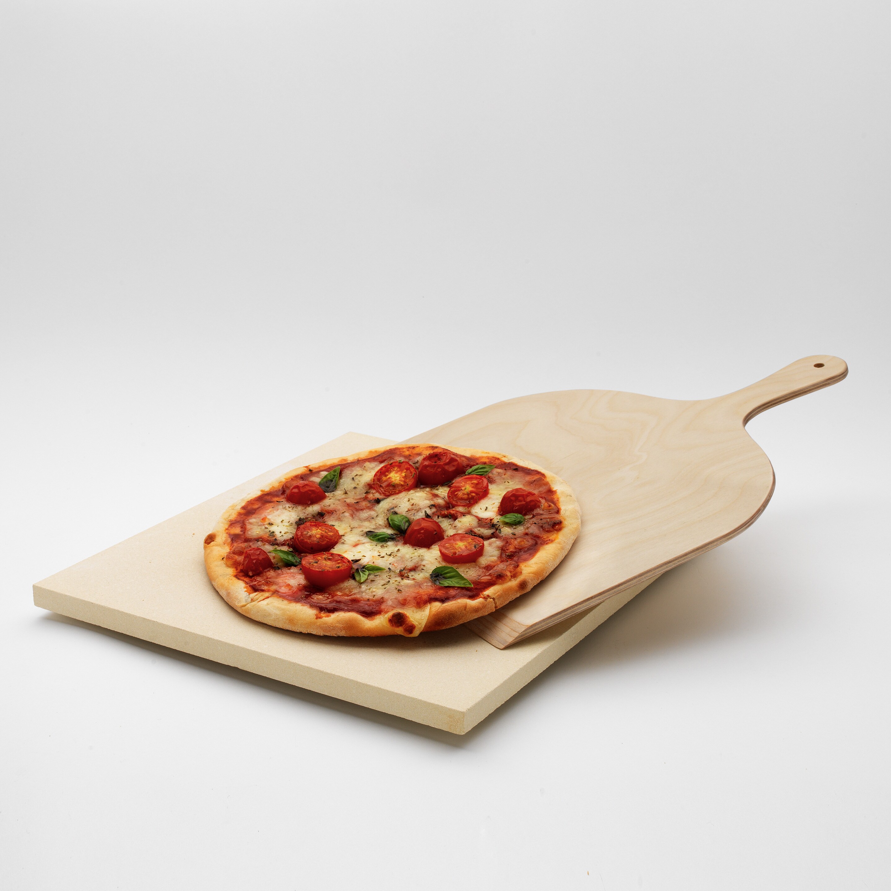 A Pizza Stone Set pizzasütő készlet, rajta pizzával