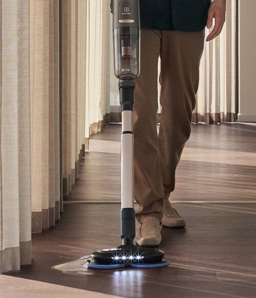 Man vacuuming with cordless cleaner in modern home