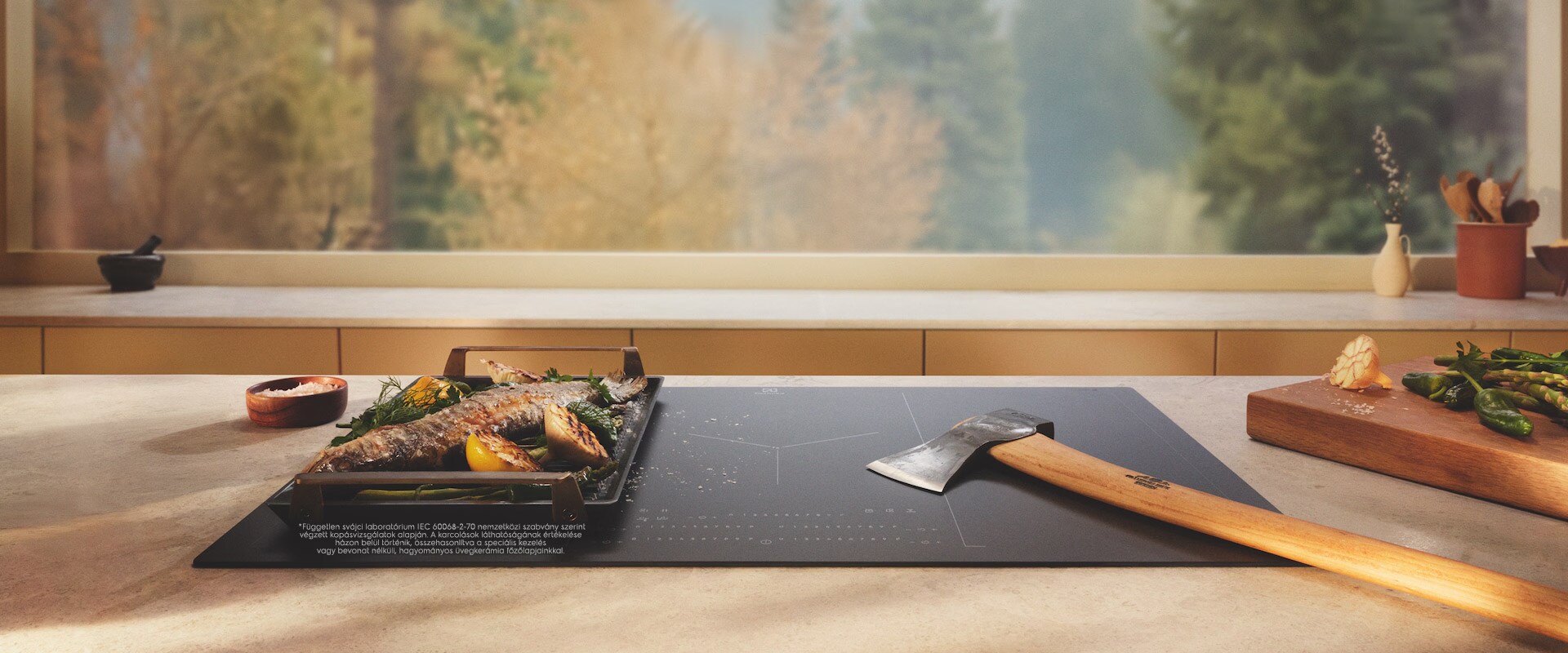 An axe is placed on an induction hob with SaphirMatt surface next to grilled food.